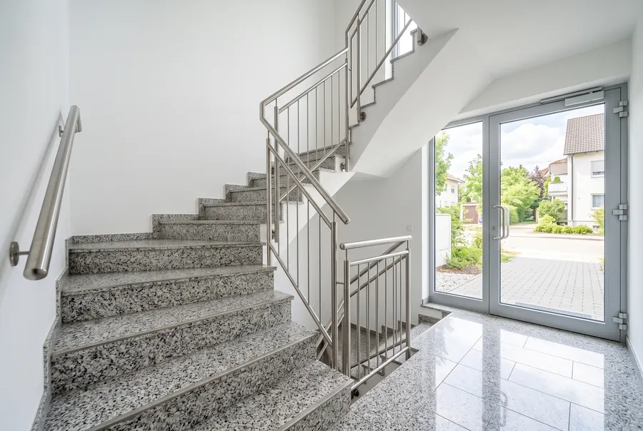 Frisch gereinigtes Treppenhaus einer Wohnanlage mit glänzendem Terrazzoboden